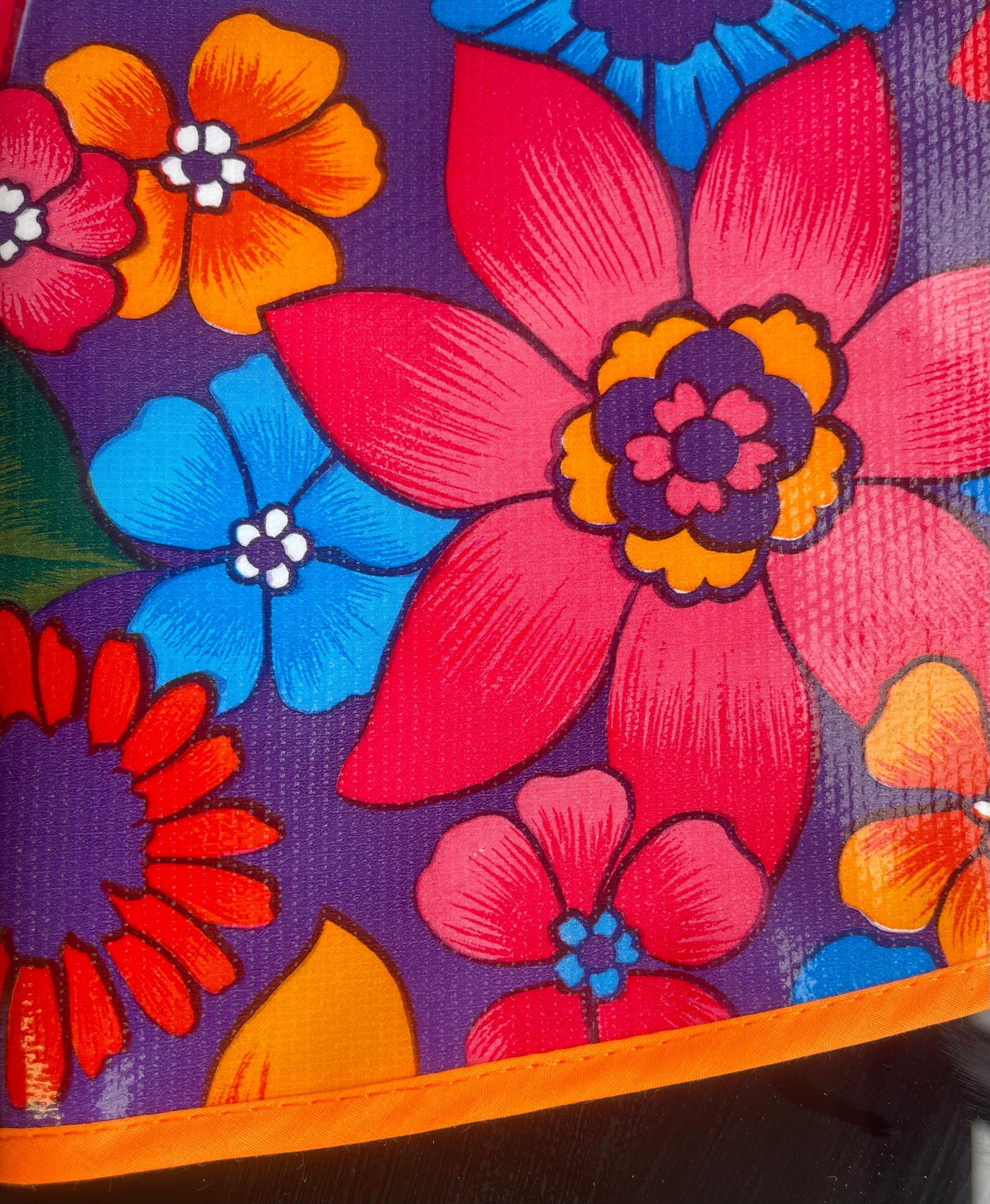 Round Purple Flora Oilcloth Tablecloths with Orange Bias Tape Trim